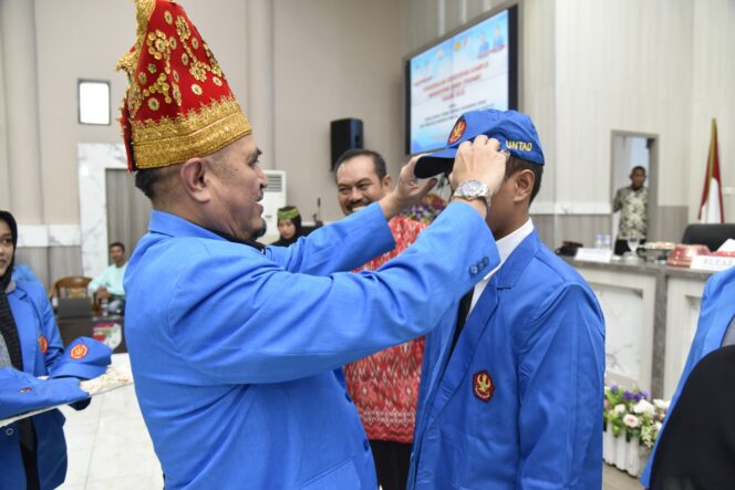 
					Rektor Untad, Prof. Dr. Ir. Amar, ST., MT., IPU., ASEAN Eng. Saat Menyematkan Almamater Kepada Mahasiswa PSDKU Tojo Una-Una, (Foto: Istimewa)