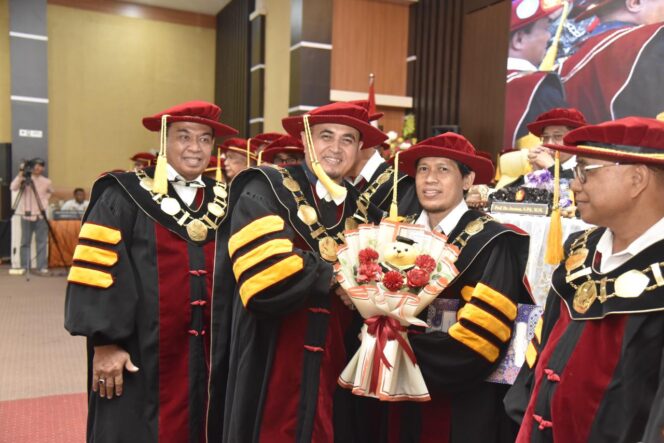 
					Rektor Universitas Tadulako Prof. Dr. Ir Amar, S.T., M.T., IPU., Asean Eng. Memberikan Baket Bunga Kepada Profesor Baru. (Foto: Istimewa)